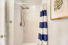 a white shower with blue and white curtains