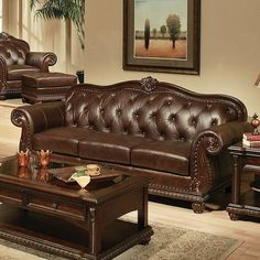 a brown leather couch sitting next to a wooden table