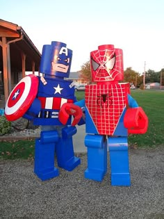 two legos dressed up as superheros standing next to each other