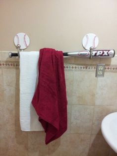 a towel is hanging on the wall next to a baseball bat and sink in a bathroom