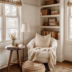 a living room with white furniture and bookshelves