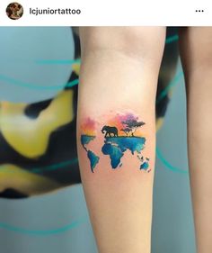 a woman's arm with a small tattoo of an elephant on the world map