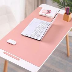 a laptop computer sitting on top of a pink desk