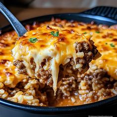 a close up of a casserole with meat and cheese on a fork in it