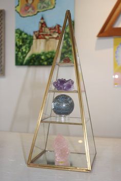 a glass display case with three different types of rocks in front of a painting on the wall