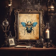 a painting with a blue beetle on it next to some candles and other things in front of it