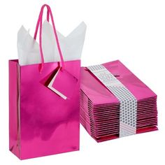 pink gift bags with white handles and ribbons