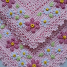 a crocheted blanket with flowers on it