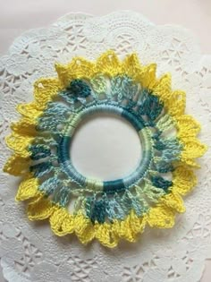 a white doily with a yellow and blue flower on it