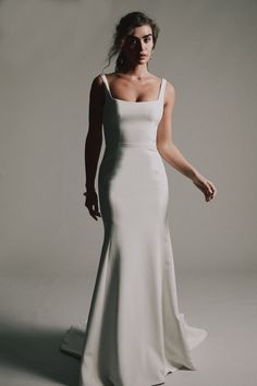 a woman in a white dress posing for the camera with her hand on her hip