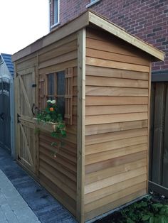 a small wooden shed sitting next to a brick building