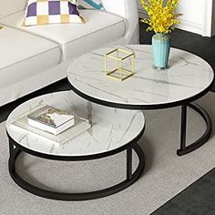 two tables sitting on top of a carpeted floor next to a couch and table