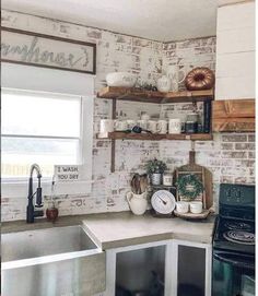 a kitchen with brick walls and open shelving above the stove