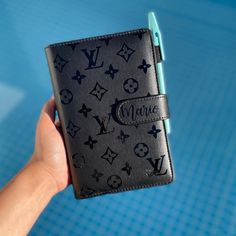 a hand holding a black and blue wallet with the word minnie written in white on it