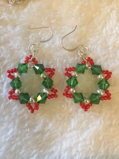 green and red beaded earrings on white fur