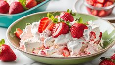 a bowl filled with whipped cream and strawberries next to another bowl full of strawberries