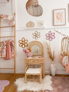 a room with white walls and wooden flooring is decorated in pastel pinks