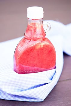 a glass bottle filled with liquid sitting on top of a napkin