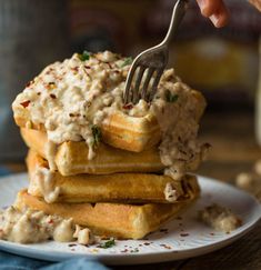 a stack of waffles topped with mashed potatoes and gravy