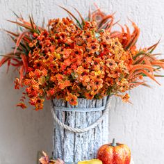 an arrangement of flowers and fruit in a basket