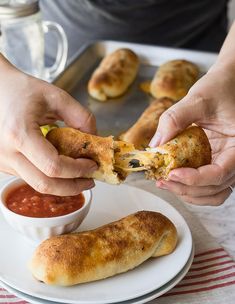 someone is dipping some food into a small white bowl on a plate with sauces