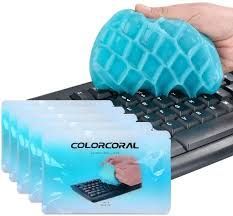 a hand is holding a blue plastic ball on top of a computer keyboard with five cards in front of it