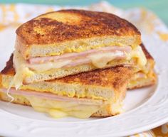 two ham and cheese grilled sandwiches on a plate