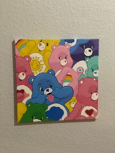 there are many different colored bears on the wall above this painting that is hanging on the wall