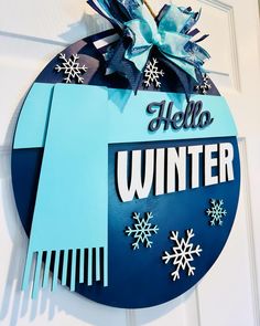 a hello winter sign hanging from the side of a door with snowflakes on it