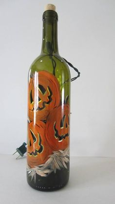 a glass bottle with pumpkins painted on it