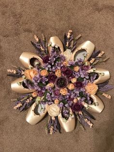 an arrangement of shoes and flowers arranged in the shape of a sunburst on carpet