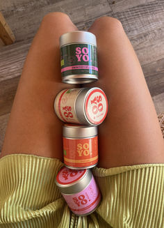 a woman's legs with six cans stacked on top of each other in front of her