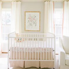 a baby's room with a white crib and pink curtains