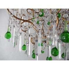 a green chandelier hanging from the ceiling with lots of glass beads on it