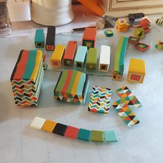 many different colored wooden blocks on a table next to scissors and other crafting supplies