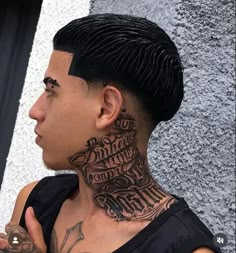 a man with black hair and tattoos on his neck