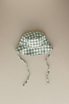 Product photos - green gingham. Our baby bucket hat will help to stay protected and keep it cute. Tailored to shade the face and ears along with side ties to keep the hat secure. A classy and comfortable choice for any forecast. Lightweight, cozy and charming. This baby bucket hat is designed to be comfortably loose-fitting and allow for growth as the baby grows. Baby Bucket Hat, Kids Outfit Ideas, Bucket Hat Outfit, Gingham Linen, Green Gingham, Outfits With Hats, Baby Grows, Gender Neutral Baby, Product Photos