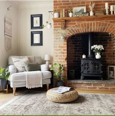 a living room filled with furniture and a fire place in front of a brick fireplace