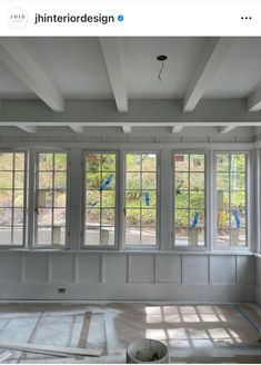 an empty room with three windows and some tape on the floor