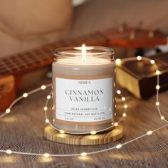 a candle sitting on top of a table next to a string of lights and a guitar