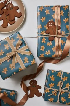 gingerbread cookies tied up and wrapped in blue wrapping paper next to two gift boxes