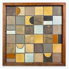 a wooden frame with an abstract mosaic design in brown, yellow and grey colors on it