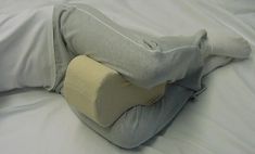 a pillow that has been placed on top of a bed with the pillows pulled back