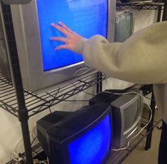 a person reaching out to touch a television