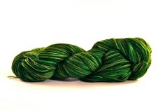 a skein of green yarn sitting on top of a white surface