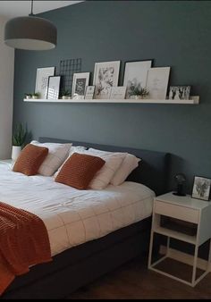 a bed with white and orange pillows in a bedroom