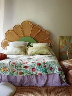 a bedroom with a bed, wicker headboard and rattan chair in the corner