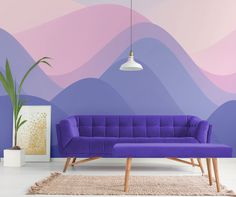 a purple couch sitting in front of a wall with mountains painted on the walls behind it