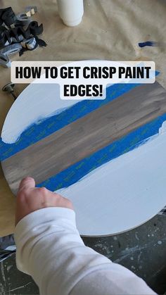 a person is painting a wooden sign with blue paint and the words how to get crisp paint edges