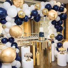 a room filled with lots of balloons and gold and white decorations on top of it